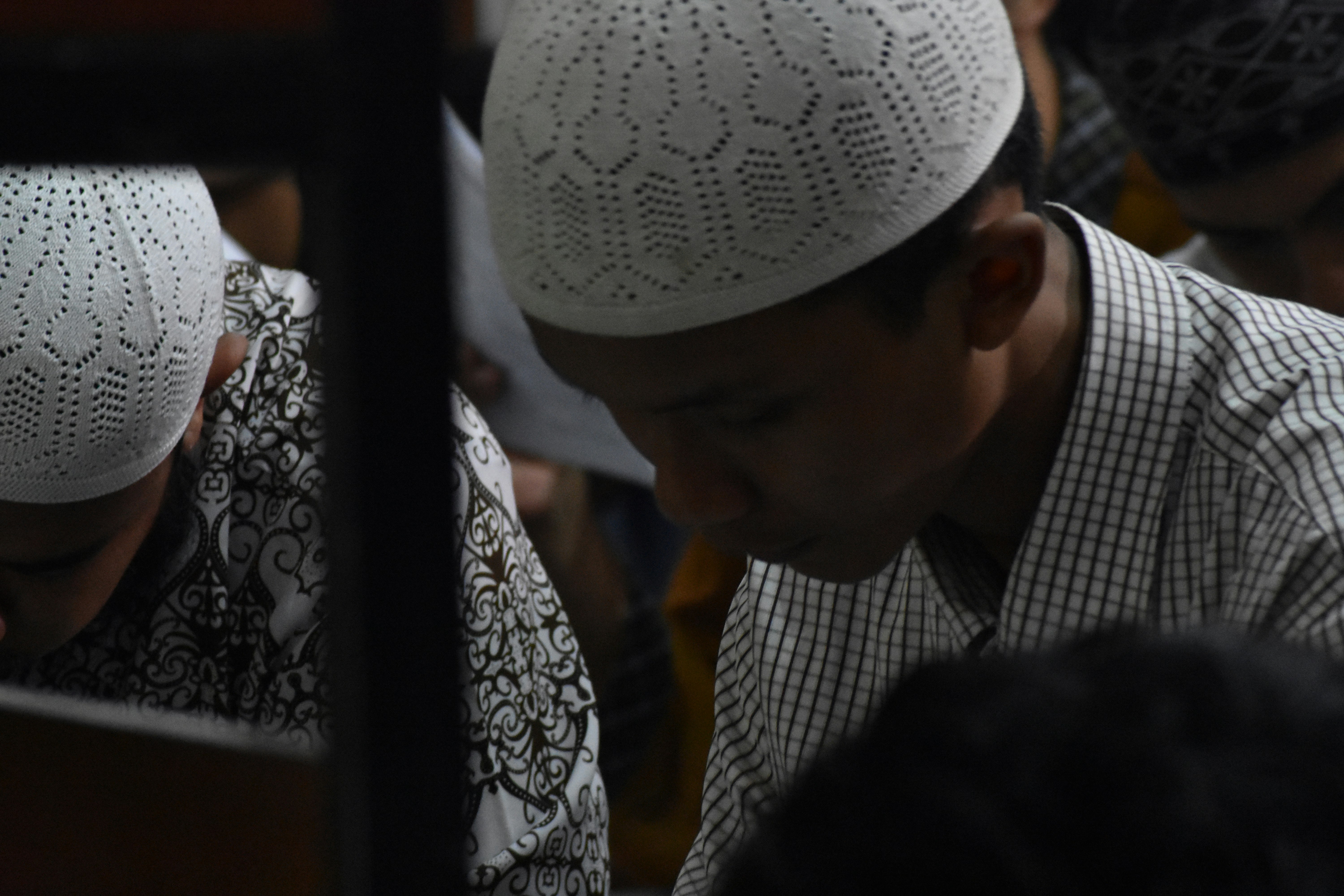 selective focus photo of man wearing taqiyah cap